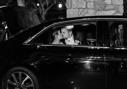 Newlyweds in luxury black car